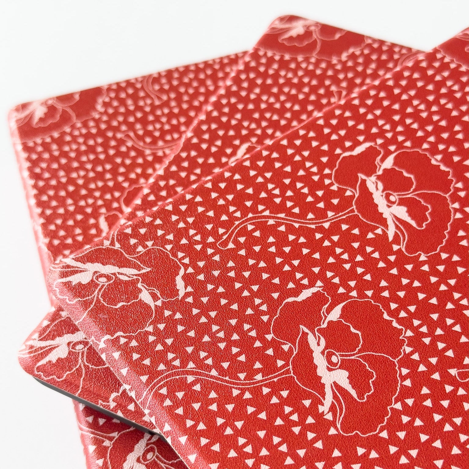 Red fabric with white floral patterns on a white background